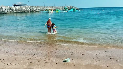 Children enter the sea from the sandy beach. Stock Footage 267201839