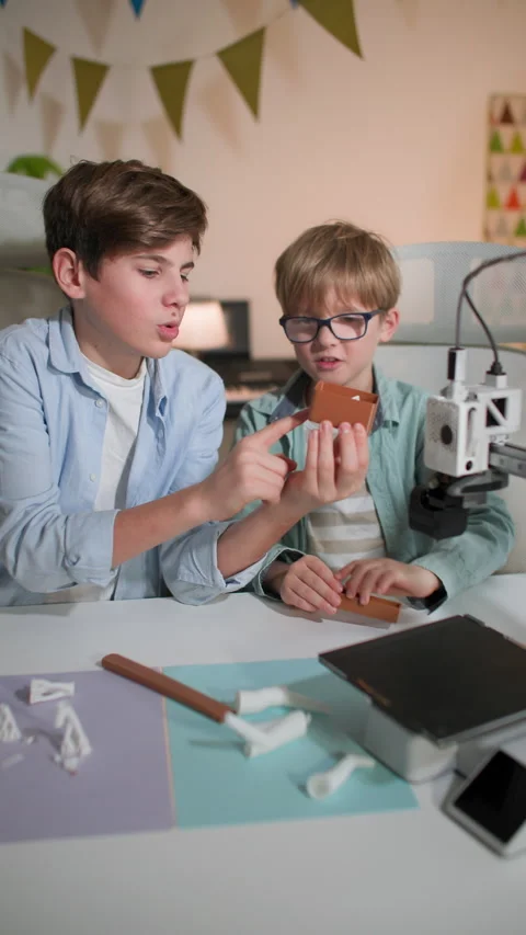Children examine the newly printed 3D part and discuss it Stock Footage 335392765
