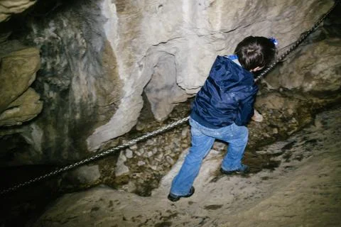 Children explore underground caves, an underground karst complex of Cunardo,  Stock Photos
