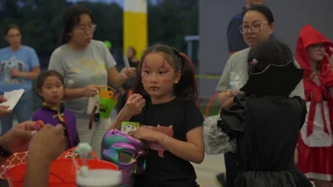 Children with Face Paint Receive Candy at Pavilion Stock Footage 318116708