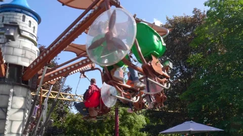 Children filled with laughter spin joyfully on colorful rides in a vibrant Stock Footage 313300907