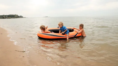 Children float on an inflatable boat near the coast Stock Footage 56297716