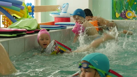 Children in floating suits learn to swim Stock Footage 132345926
