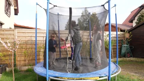 Children friends have fun play jump together on trampoline on backyard Stock Footage 152951753