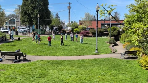 Children gather in a circle playing games at a charming community park Vídeo Stock 337363899