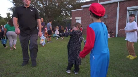 Children Gather on the Grass at Trunk-Or-Treat Stock Footage 318109431