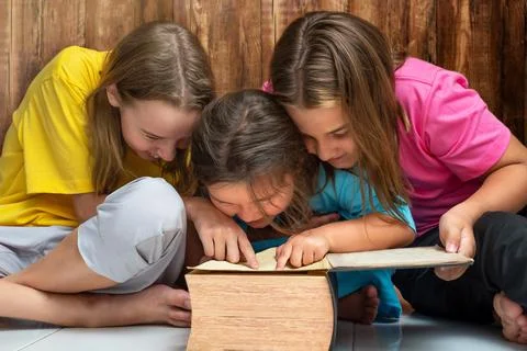 Children girls show and look at the book Stock Photos