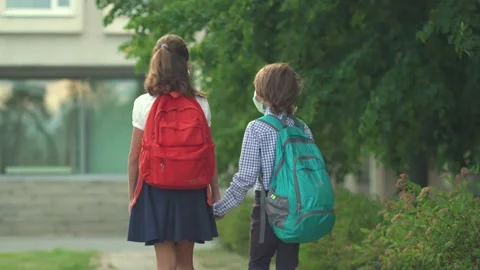 Children go back to school. Cute pupils with backpacks. Boy and girl in safety Stock Footage 136260799