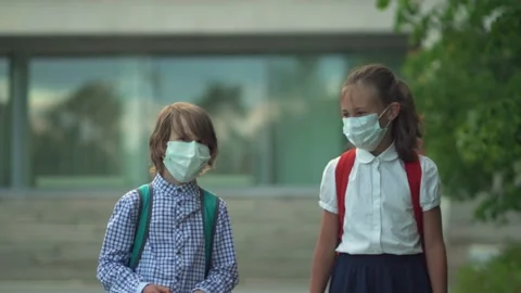 Children go back to school. Cute pupils with backpacks. Boy and girl in safety Stock Footage 136512123