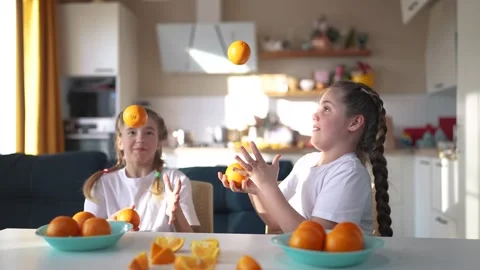 Children group juggle oranges fruit food in the kitchen. healthy eating concept Video stock 274649728