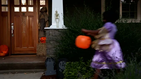 Children in Halloween costumes trick or treating Stock Footage