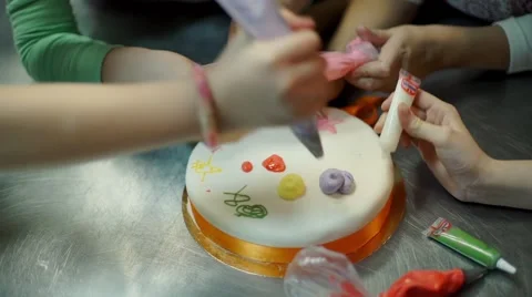 The children hands are painting on the cake Stock Footage 57498853