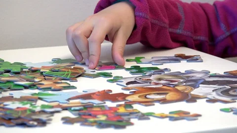 Children hands assembling puzzle on table, closeup Stock Footage 87075258