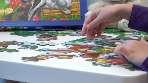 Children hands assembling puzzle on table, closeup Stock Footage 87077351