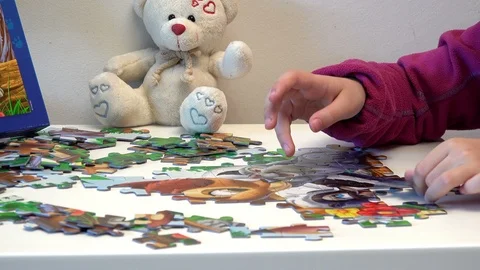 Children hands assembling puzzle on table, closeup Stock Footage 87077368
