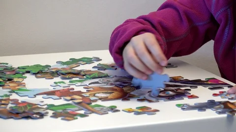 Children hands assembling puzzle on table, closeup Stock Footage 87078811