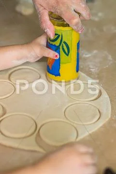 Children hands cook the circles of dough Stock Photos