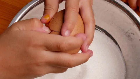 Children hands cracking an egg into a stainless steel container with batter. Stock Footage 158659282