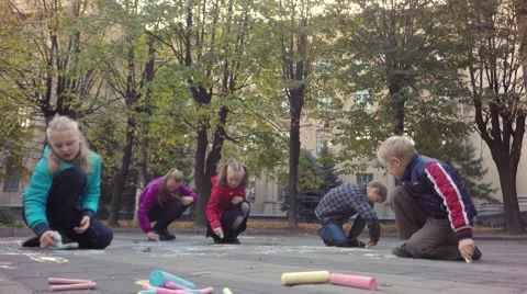 Children happily drawing colored chalk paintings on the streets. Stock-Footage 68763445