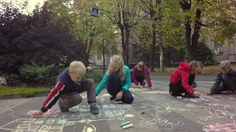 Children happily drawing colored chalk picture on the footpath. Video stock 68763540