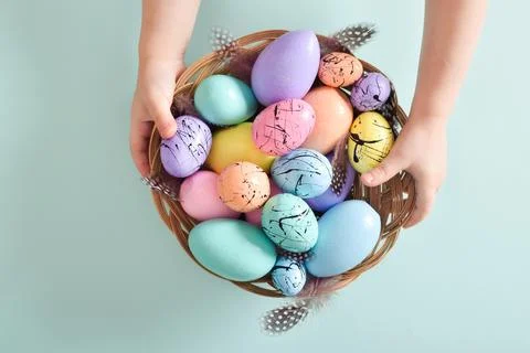 The children have a basket with Easter eggs and feathers in their hands. Foto stock