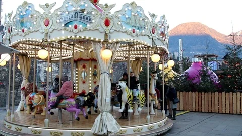Children have fun on a carousel decorated with Christmas lights Stock Footage 100232679