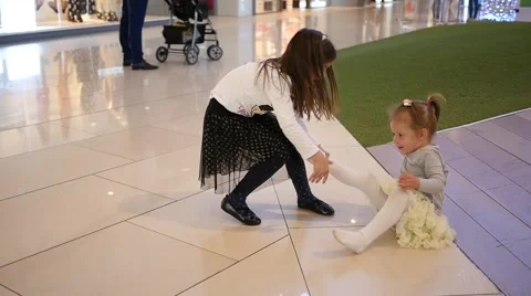 Children have fun playing drag leg little girl slide down floor mall playground Stock Footage 63668183