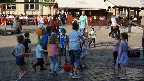 Children have fun playing making soap bubbles WroclawPoland public city center Stock Footage 88994126