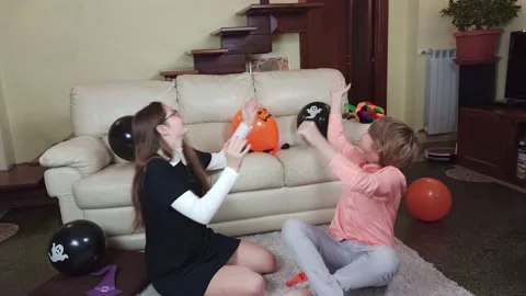 Children having fun and playing with orange and black Halloween baloons Stock Footage 141039682