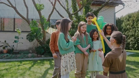 Children having fun on balloon show at a backyard birthday party on a sunny day Stock-Footage 197878079