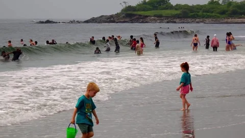 Children having fun at the beach in the waves Stock Footage 337442266