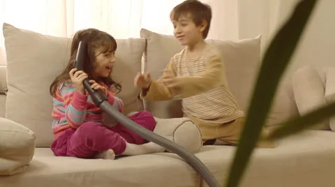 Children having fun playing with vacuum cleaner. Stock Footage 22920241