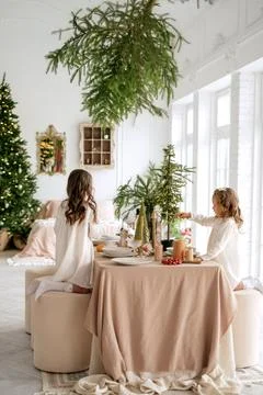 Children help to set  table on Christmas Eve before arrival of guests. Stock Photos