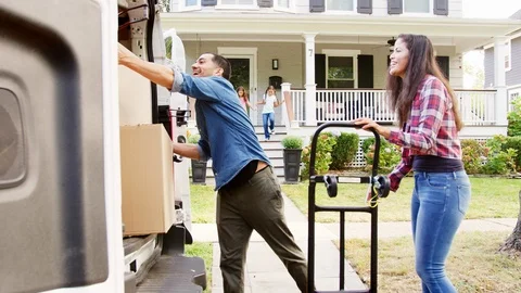 Children Helping Unload Boxes From Van On Family Moving In Day Stock Footage