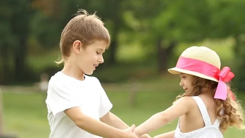 Children hold hands and start to circle together in the summer park. Slow motion 스톡 동영상 77591902