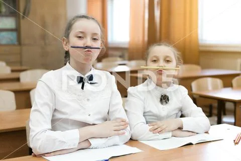 Children indulge in school in the classroom make face mimicry. Stock Photos