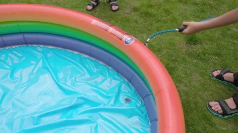 Children inflate a small pool with a pump Stock Footage 201741498