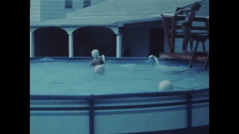 Children jumping and playing in above ground pool in 1961 Stock Footage 326896571