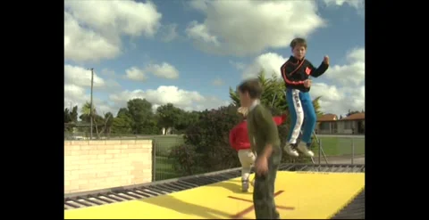 Children Jumping On Backyard Trampoline – Australia 1990s Stock Footage 318349356