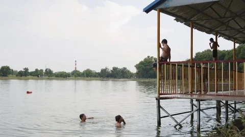 Children jumping from waterfront Stock-Footage 77565230