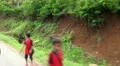 Children in jungle village coming from school HD Footage