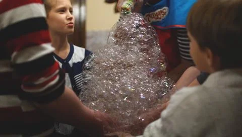 Children keep the soap bubbles in a hands in a cafe Foto stock