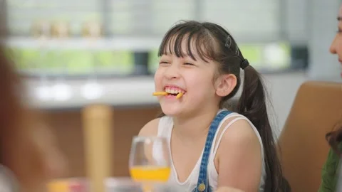 Children laugh at the dining table and have fun during lunch at home. Stock Footage 201524960