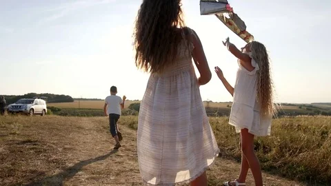 Children launch a kite at sunset Видео 80349585