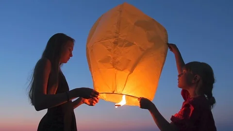 Children launching flying sky lantern to make a wish Stock Footage 125036634