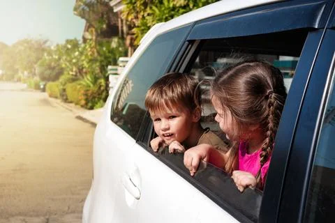 Children lean out of the car window Stock Photos