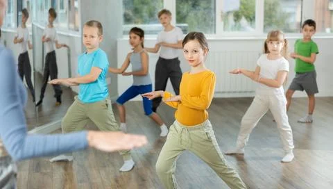 Children learn to dance modern dances, repeat movement for unrecognizable Stock Photos