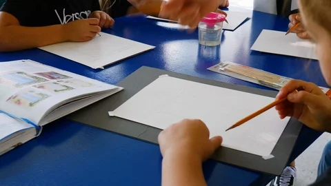 Children learn to draw. the teacher talks about the subtleties of drawing Stock Footage 124841807
