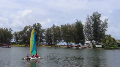 Children learn to sail on the lake on a small training dinghy Stock Footage 217499080