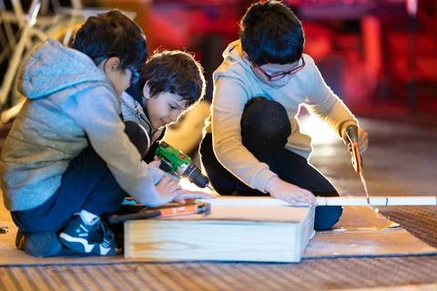 Children learning and creating with tools and wood 스톡 사진